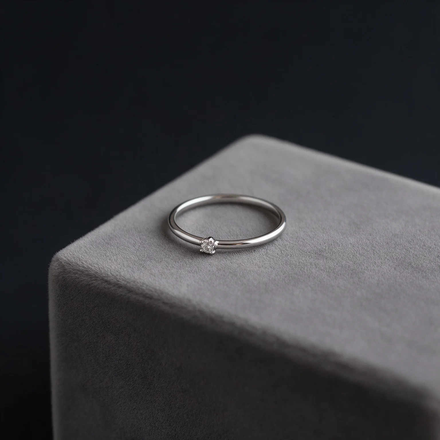 Anillo solitario de plata sobre terciopelo gris