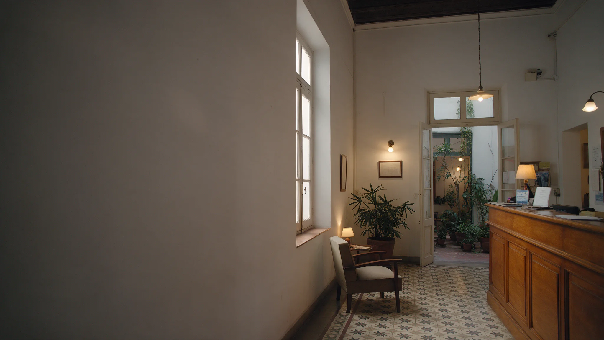 La recepción del hotel en una casona restaurada, con mostrador de madera y piso calcáreo